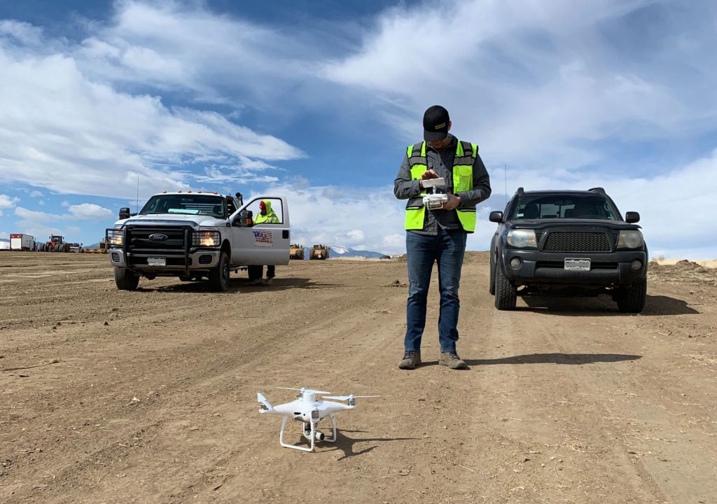 Drone surveying on site with trucks in summer