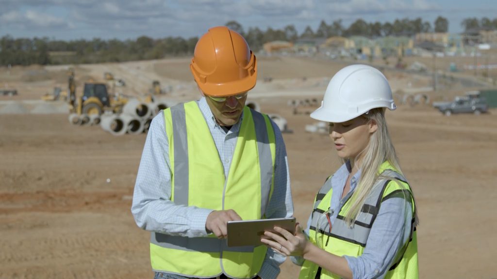 two construction workers looking at tablet