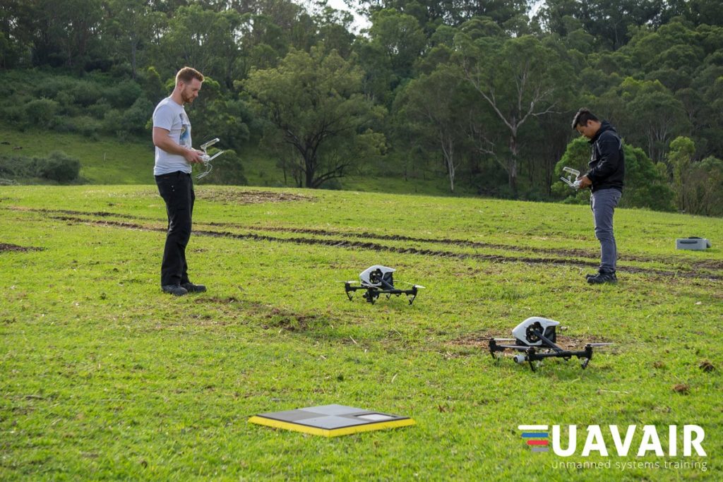 Two drone pilots in a field ready to start a flight. AeroPoint is in the foreground.