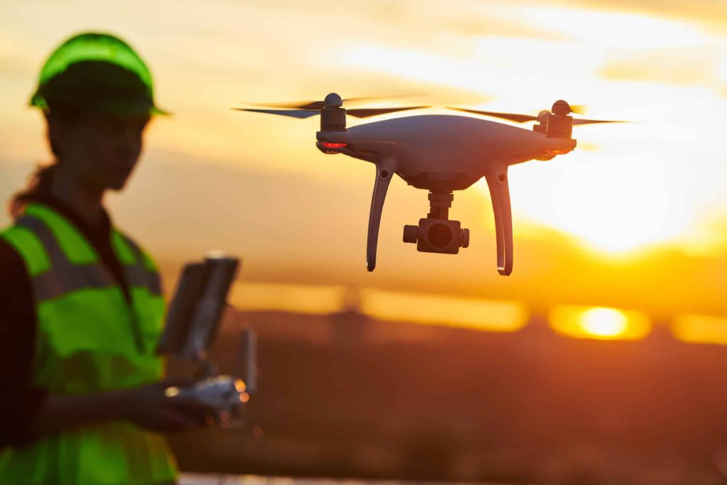 Construction female worker piloting drone at building site