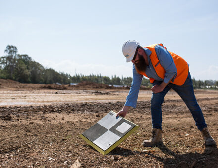 Man placing AeroPoint on the the ground of a site before drone survey