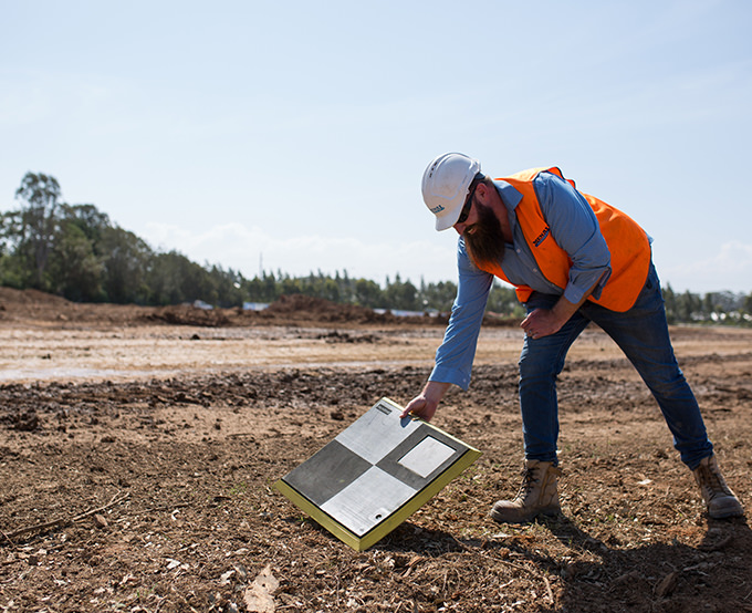 Man placing AeroPoint on the the ground of a site before drone survey