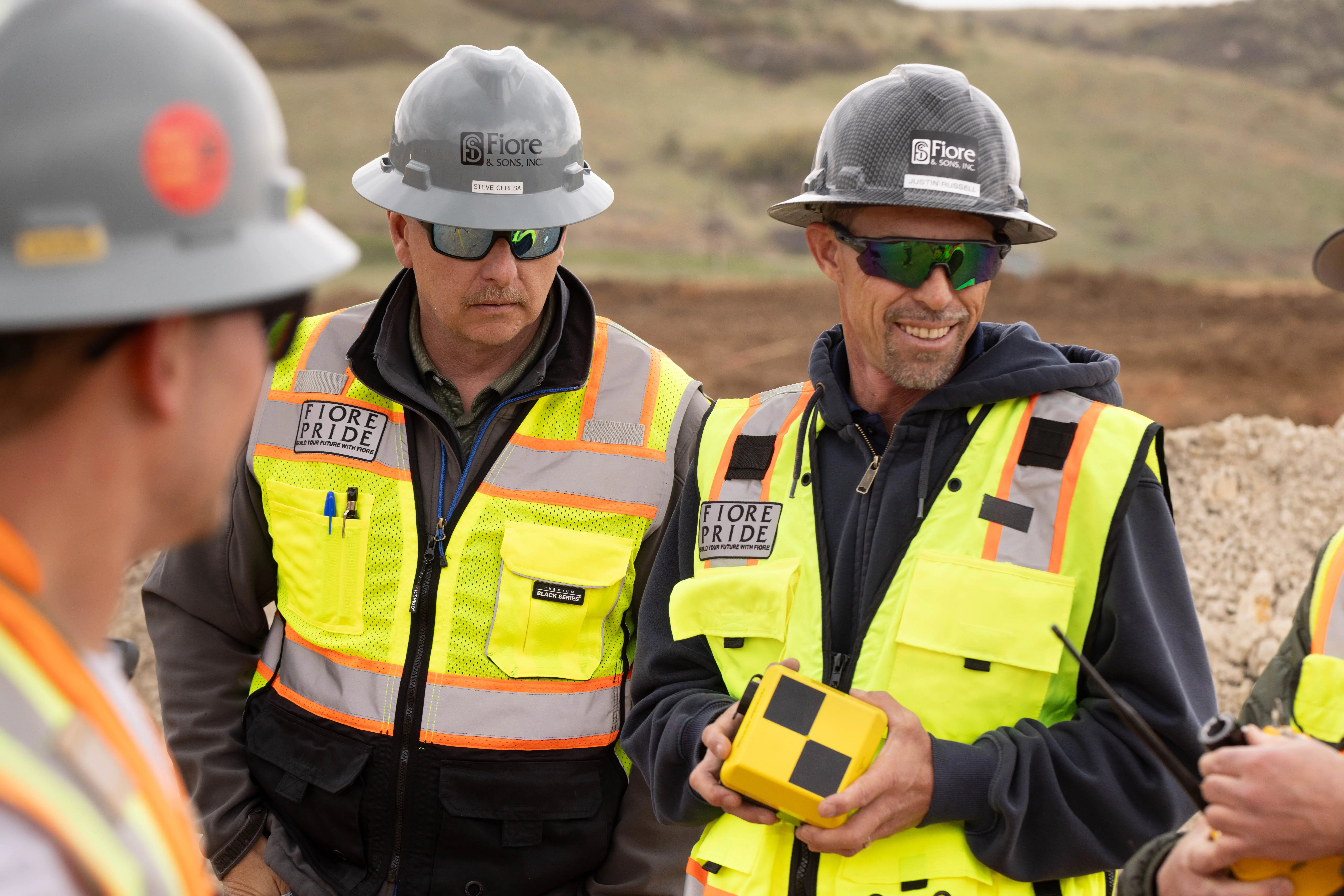Group of construction worker talking to eachother and holding a dirtmate on a construction worksite
